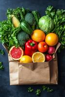 Fresh produce assortment in a brown paper bag on a textured black surface photo