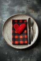 Elegant table setting with fork, plaid napkin, and greenery on a rustic plate photo