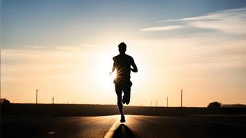 Silhouette of a man in mid stride along a roadway backlighted by the first sun light rays of dawn piercing photo
