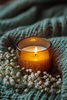 Cozy candlelight illuminating delicate flowers on a soft blanket in a warm setting photo