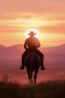 Cowboy riding a horse during sunset in a serene mountain landscape photo