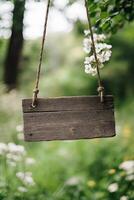 Rustic wooden sign hanging in a forest with blurred greenery in the background photo