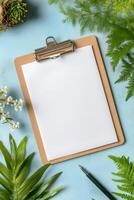 A blank clipboard and pens resting on a vibrant turquoise background for creative tasks photo