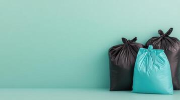 Black and teal garbage bags lined up against a solid turquoise background in a clean setting photo