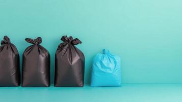 Black and teal garbage bags lined up against a solid turquoise background in a clean setting photo