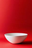 Simple white bowl on a vibrant red background capturing modern minimalism photo