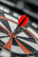 Red dart striking the bullseye on a dartboard in a game setting photo