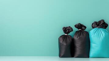 Black and teal garbage bags lined up against a solid turquoise background in a clean setting photo