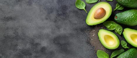 Fresh green avocados, spinach, and chia seeds arranged on a stone surface for healthy eating photo