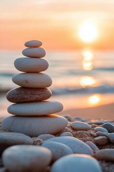 Balanced stones stacked on the beach with a beautiful sunset in the background photo