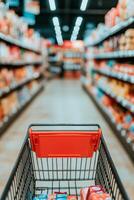 Shopping cart in a grocery store aisle filled with colorful product packages during the day photo