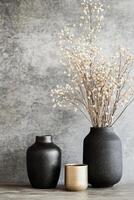 Black vases with dried flowers on a textured dark background in a minimalist style photo