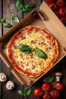 Delicious cheese pizza topped with mushrooms and fresh basil in a takeout box on wooden table photo