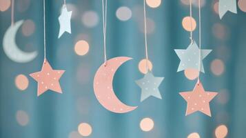 Decorated ceiling with paper stars and moon hanging against a teal backdrop with lights photo