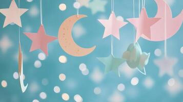 Decorated ceiling with paper stars and moon hanging against a teal backdrop with lights photo