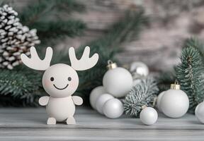 Cute wooden reindeer figurine beside Christmas ornaments and pine branches during winter photo