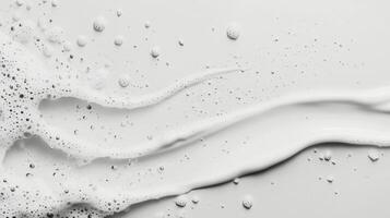 Smooth white cream flowing across a flat surface with bubbles and droplets captured in detail photo