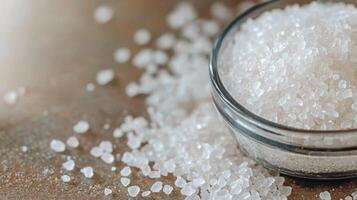 Freshly poured salt in a glass bowl on a rustic wooden table at home in natural lighting photo