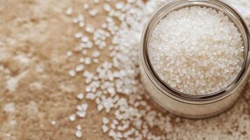 Freshly poured salt in a glass bowl on a rustic wooden table at home in natural lighting photo