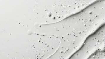 Smooth white cream flowing across a flat surface with bubbles and droplets captured in detail photo