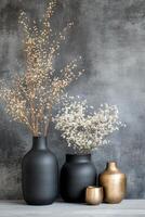 Black vases with dried flowers on a textured dark background in a minimalist style photo