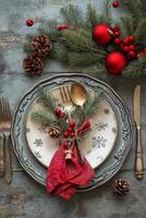 Festive holiday table setting with plaid napkin, silver cutlery, and pine cone decoration photo