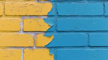 Two-tone brick wall divided into blue and yellow sections with peeling paint in urban setting photo