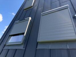 Opening external blinds on the skylight with remote control and mains power. Aluminum shutters on the roof window. photo