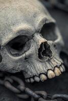 Close-up of an aged human skull with chains against a dark background, evoking eerie atmosphere photo