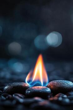 Flames rising from smooth stones on a dark surface in a tranquil setting photo