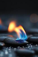 Flames rising from smooth stones on a dark surface in a tranquil setting photo