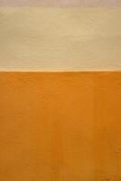 Vibrant orange wall texture with a subtle beige stripe, perfect for background, design inspiration or artistic project. Image of imperfections and unique details of an outdoor painted surface. photo