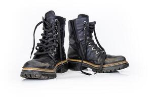 Pair of rugged worn black ankle leather combat boots with thick, sturdy soles and laces. Two vintage military style shoes. Studio light. Isolated on white background. Empty copy space. Clipping path photo
