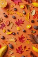 Vibrant fall flat lay featuring oranges, bananas, and colorful autumn leaves on a bright backdrop photo
