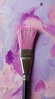 A close-up view of a paintbrush with vibrant purple paint on a textured pastel background photo
