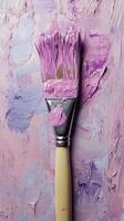 A close-up view of a paintbrush with vibrant purple paint on a textured pastel background photo