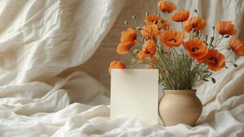 Minimalist still life with dried flowers and blank canvas on soft draped fabric indoors photo