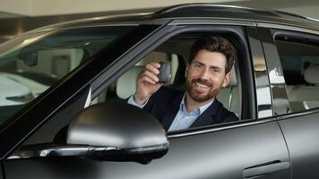 Happy Caucasian man driver smile owner buyer new car rent service vehicle inside transport male showing key client customer sitting guy auto business salon automobile enjoying businessman dealership video