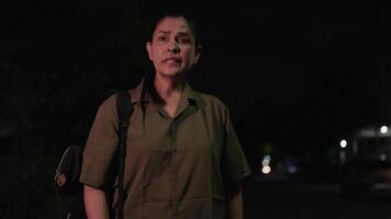 A woman stands alone, her expression a poignant blend of anticipation and frustration as she waits, , her body language and frequent checks of her phone conveying a sense of restlessness and concern video