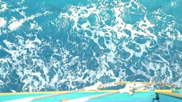 Sea waves with white foam float past deck of ship sailing on sea, top view of deck. video