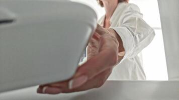 Woman puts food in refrigerator in plastic disposable container, angle from inside refrigerator, hand and box close-up. video
