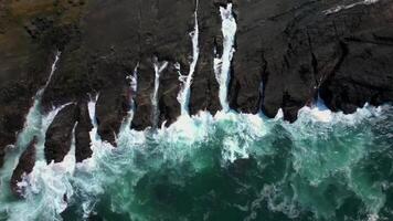Drone View The Beauty of Waves Crashing Against Rocky Cliffs. This drone footage captures the stunning view of waves crashing against rocky cliffs. video