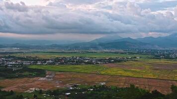 top view of rice fields with villages on background of mountains in Vietnam in Asia in evening video