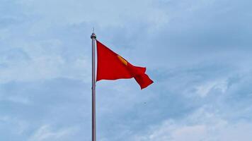 Vietnamese flag on flagpole flutters in the wind against a cloudy sky video