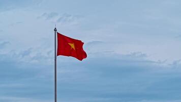 Vietnamese flag on flagpole flutters in the wind against a cloudy sky video