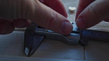 Hands of Engineer using vernier caliper to scale the metal piece, video