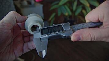 Hands of Engineer using vernier caliper to scale the metal piece, video