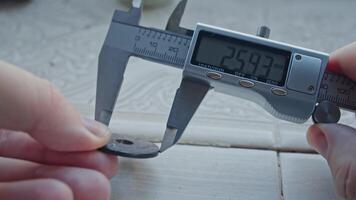 Hands of Engineer using vernier caliper to scale the metal piece, video