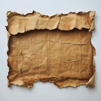 A vintage piece of torn brown paper with rugged edges and crumpled texture lying flat photo