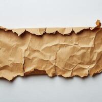 A vintage piece of torn brown paper with rugged edges and crumpled texture lying flat photo